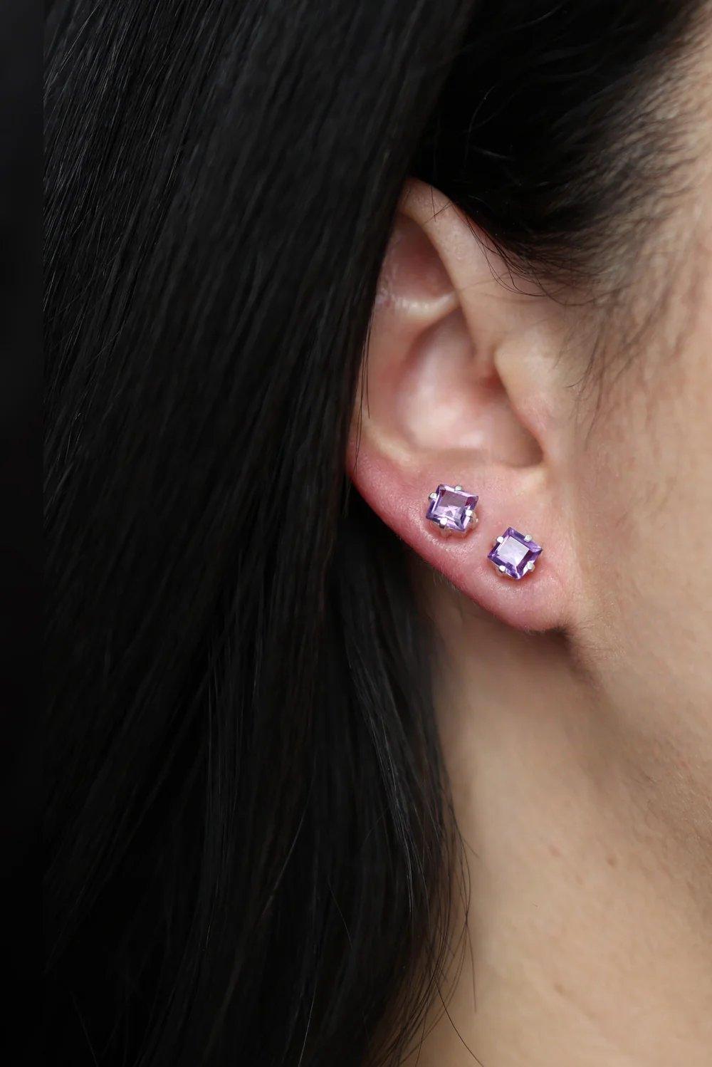 A pair of handcrafted silver gemstone earrings featuring a beautiful amethyst stone